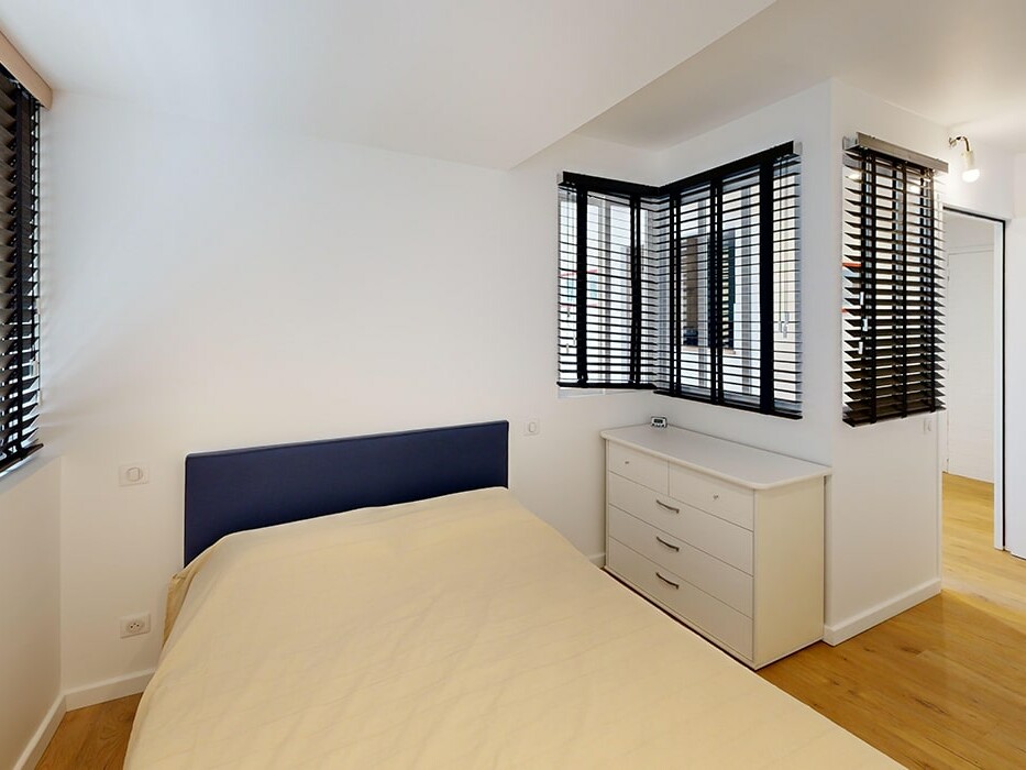 Chambre lumineuse avec parquet et décoration minimaliste